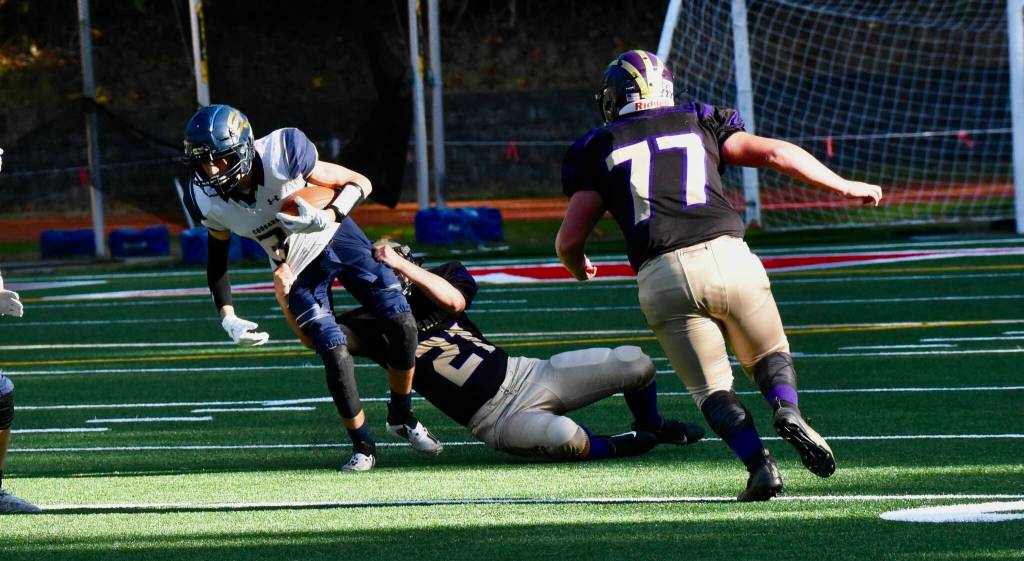 Wolverine Cody Anderson, #21, wraps up Cougar running back with Tate Geiser, #77, heading in for assistance. (John Stimpson photo)