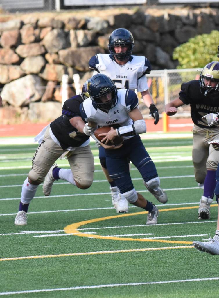 Wolverine Chris Gustafson, #24, wraps up the Cougar running back. (John Stimpson photo)