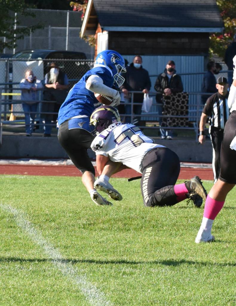 Wolverine Tate Geiser, #77, drops Falcon running back in the back field. (John Stimpson photo)