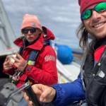 Team Elsewhere crew member Odin Smith and Captain Rhys Balmer smile during the 2022 R2AK Race To Alaska.