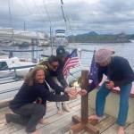 Team Elsewhere pose at the finish line of the 2022 R2AK Race to Alaska, in Ketchikan Alaska.