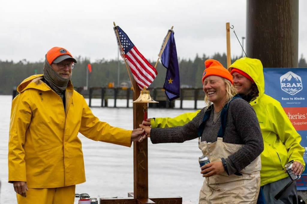 Team Sockeye Voyages captain John Calogero, along with Tara Watkins and Olivia Lord, ring the finish line bell, officially ending the 2022 R2AK Race To Alaska.