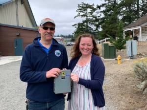 San Juan County/Contributed photos
Top: Close-up view of the panels. Bottom: Fair building roof from above.
Heather Spaulding/Staff photo
Middle: Greg Sawyer and Christine Minney activate the solar grids.