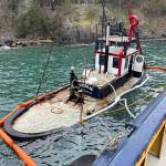 Contributed photo.
The partially submerged Tugboat Tulalip is suspended alongside a response vessel near the Lopez ferry terminal in preparation for removal.