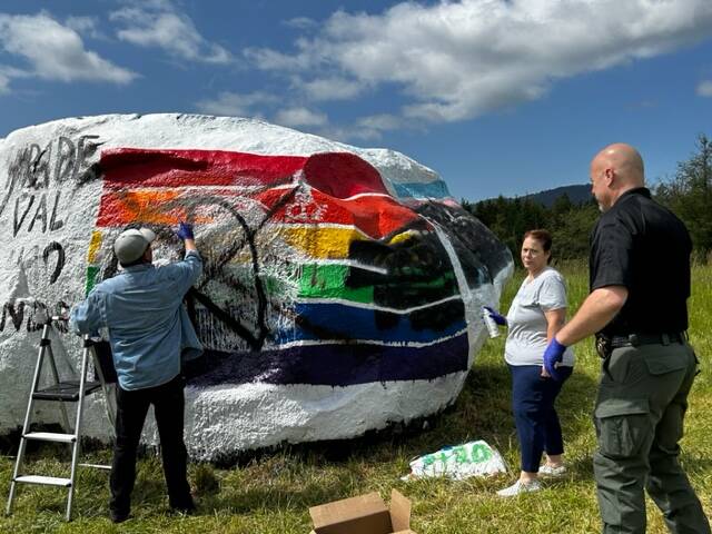 Heather Spaulding  Staff photo
Community members and Sheriff Eric Peter working to fix the vandalized Pride flag.