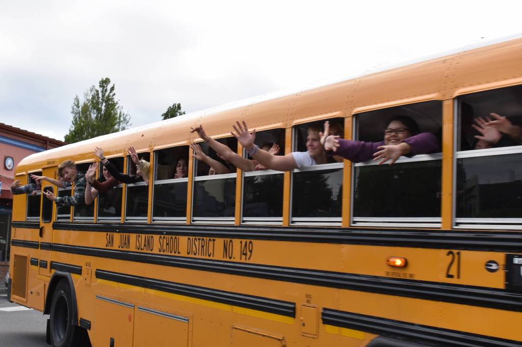 Kelley Balcomb-Bartok / Staff photo
Friday Harbor graduates wave from the school bus as they parade through the streets of Friday Harbor.