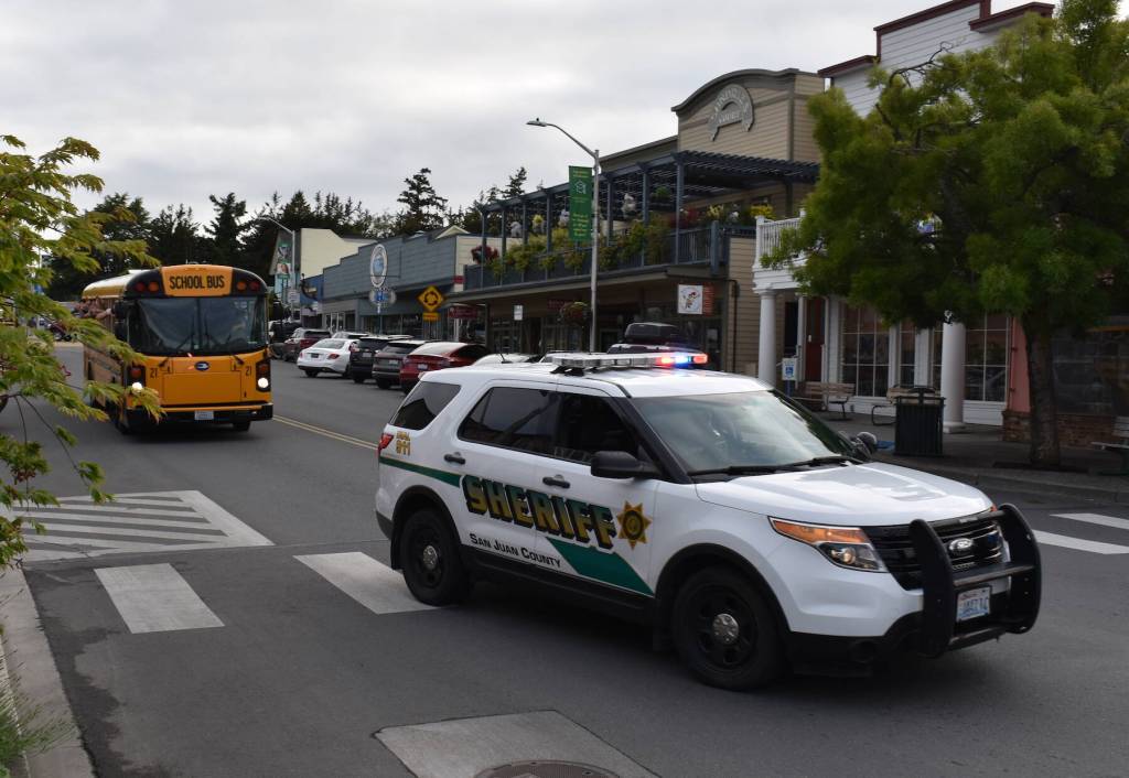 Kelley Balcomb-Bartok / staff photo
San Juan County Sheriff's Deputy Nick Wainwright led the bus containing the Friday Harbor High School graduates as they drove through downtown Friday Harbor with honking horns, sirens, and flashing lights.