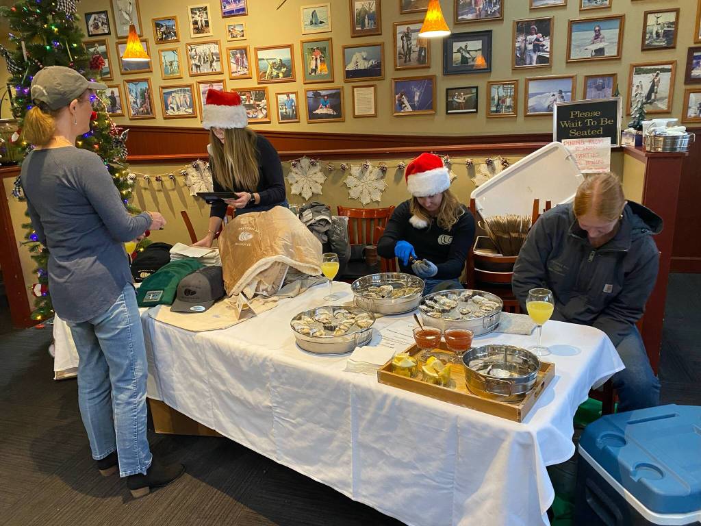 Isabel Ashley/Staff Photo
Wescott Bay employees shuck oysters at a pop-up.