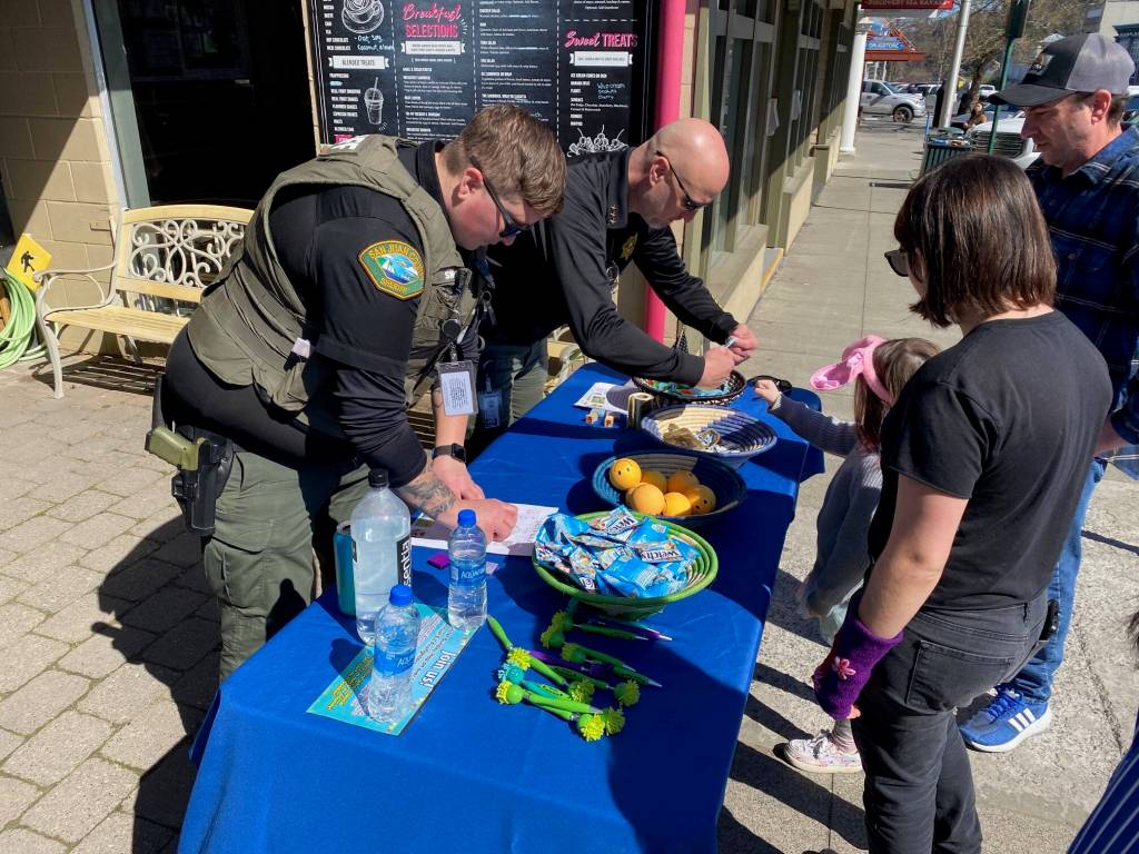Isabel Ashley \ Staff photo
Sheriff Eric Peter hands out bracelets as another officer adds stamps to a childs passport to get an Easter treat.
Isabel Ashley \ Staff photo
Sheriff Eric Peter hands out bracelets as another officer adds stamps to a childs passport to get an Easter treat.