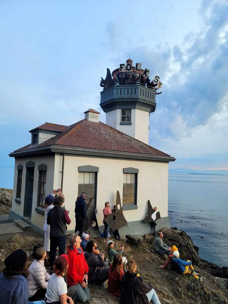 Contributed photo by Sarah Leske
Attendees scattered below the Lighthouse and holding a FOLKS sign on top of the Lighthouse while waving to Chris Teren who took photos from above via a drone.