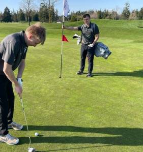 Contributed photo
Fisher Goosman putts on the 11 hole with teammate Finn Graham tending the pin.