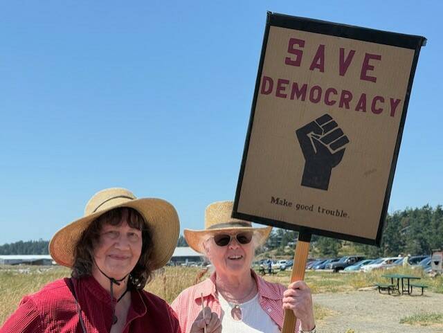 Heather Spaulding \ Staff photo
Islanders hold up their signs July 17.