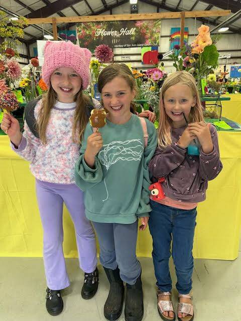 Staff photo \ Kristina Stucki
Charlotte Arrowsmith, Harmony Hall and Georgia posing with the flower display.
