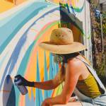 Stephen Mitchell photo.
A woman spray paints a mural.