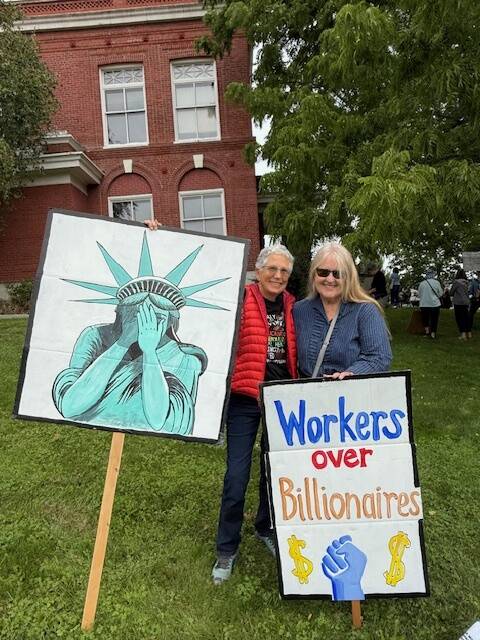 Liza Michaelson and Lovell Pratt holding their signs.