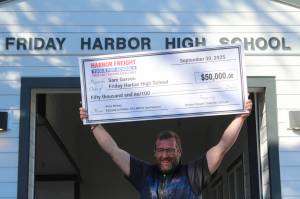 Heather Spaulding photo.
Sam Garson holds the check over his head.